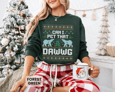 A woman wearing a green sweater with a Christmas tree in the background and holding a mug with a Santa Claus design.